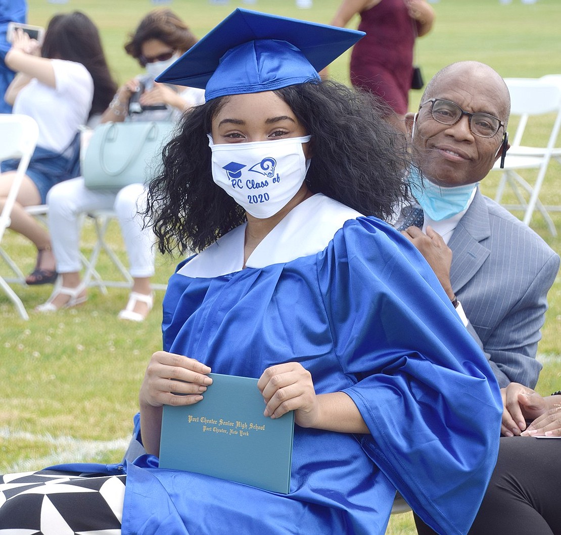 Adetola Okunoye presumably smiles behind her Class of 2020 face mask after receiving her diploma.