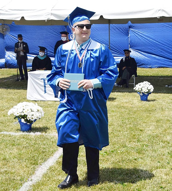 Joseph DeCarlo looks extra cool in his shades as he clutches his fresh diploma and marches back to his box.