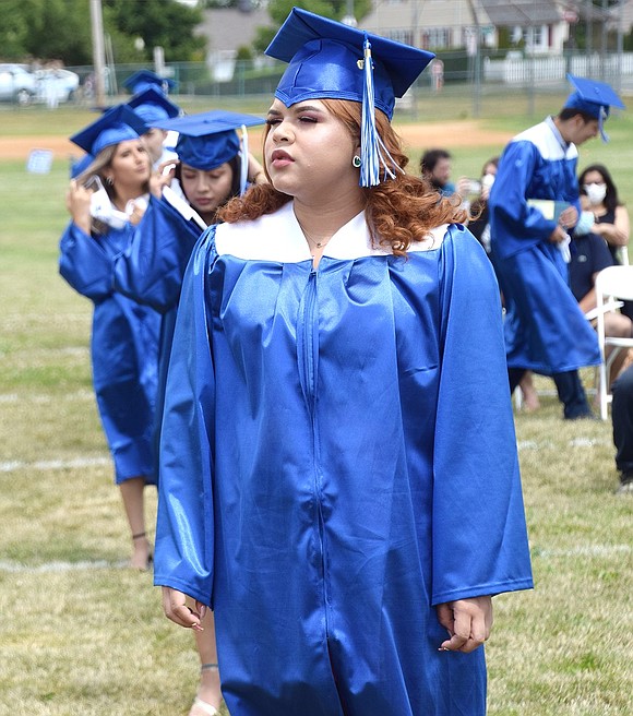 Adriana Hernandez graciously waits for her name to be called so she can pick up her diploma.