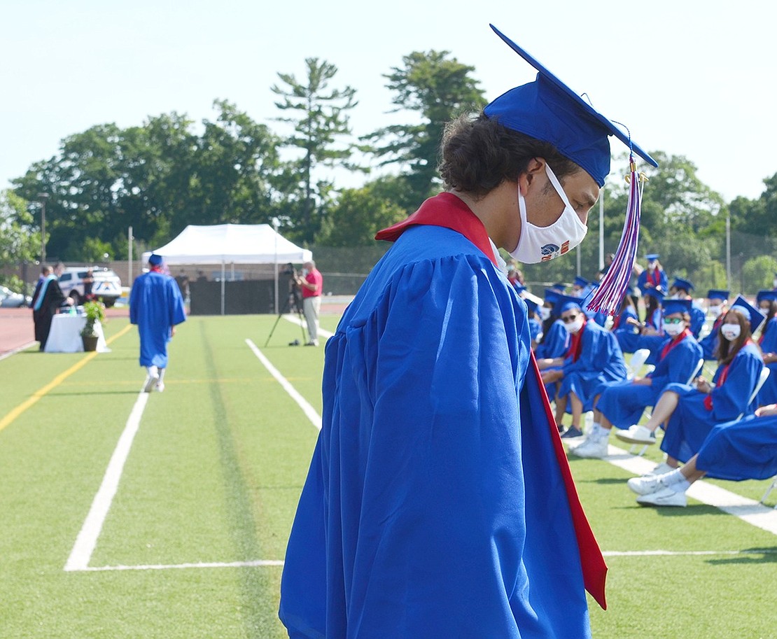 Adam Marek takes a pensive moment to collect his thoughts before his name gets called to walk across the field toward his diploma.