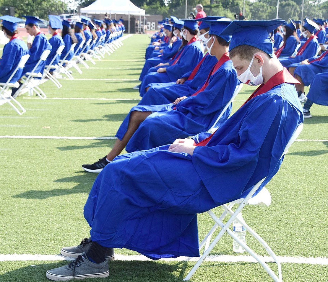 Zachary Richman looks down at his clasped hands while listening to speakers commemorate their historic class.