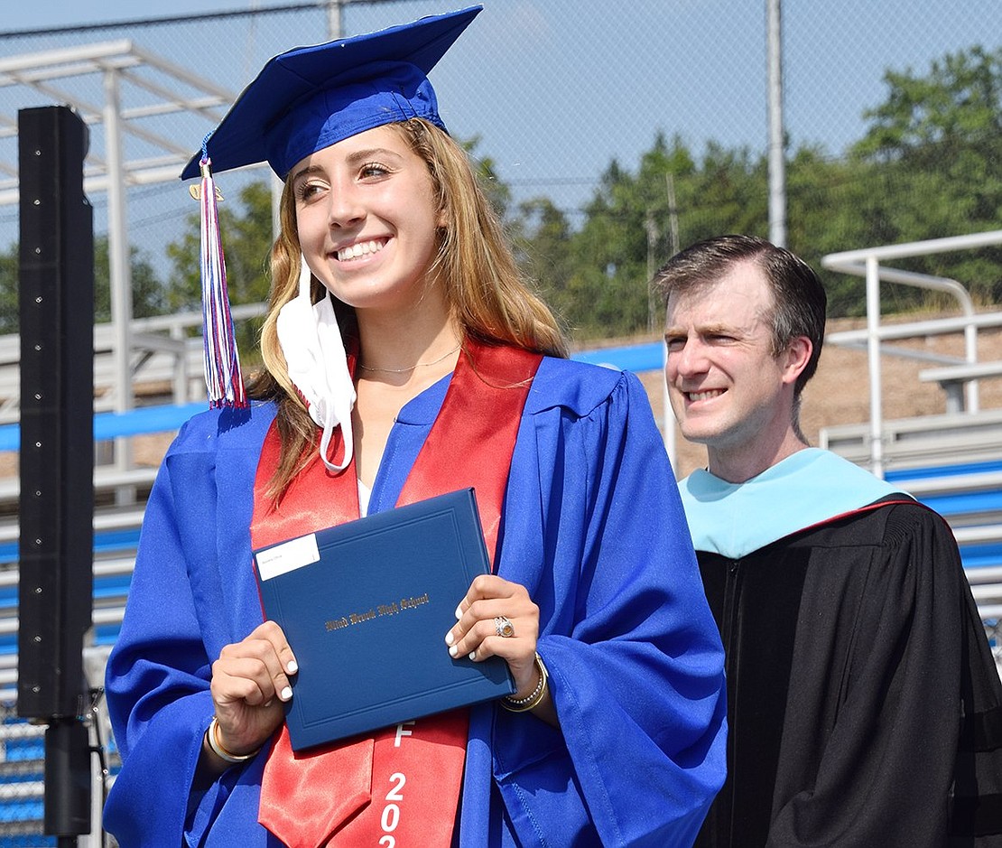 All smiles and positive energy, Olivia Jaccoma poses for a photo with her fresh diploma in hand.