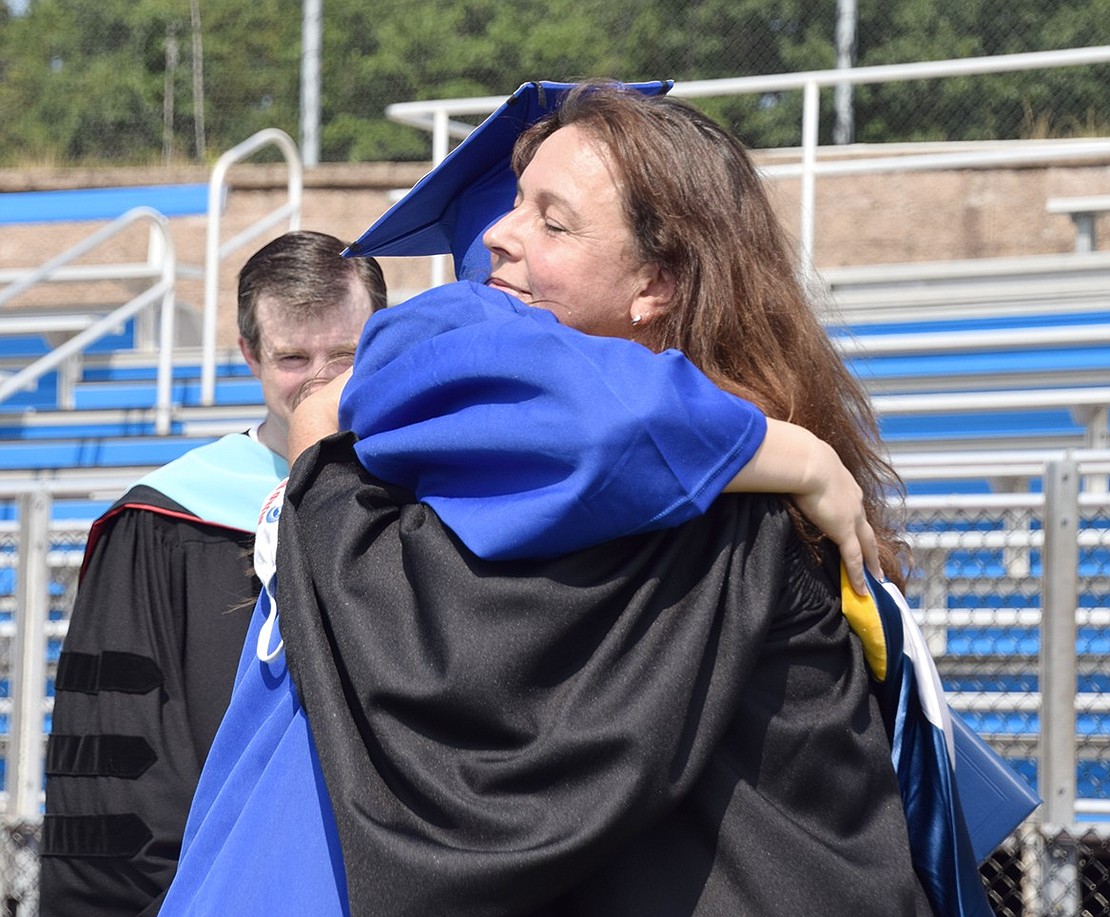 The only hug permitted at the ceremony was for Abby Schlactus, who received her diploma from her Board of Education member mother Jennifer Schlactus.