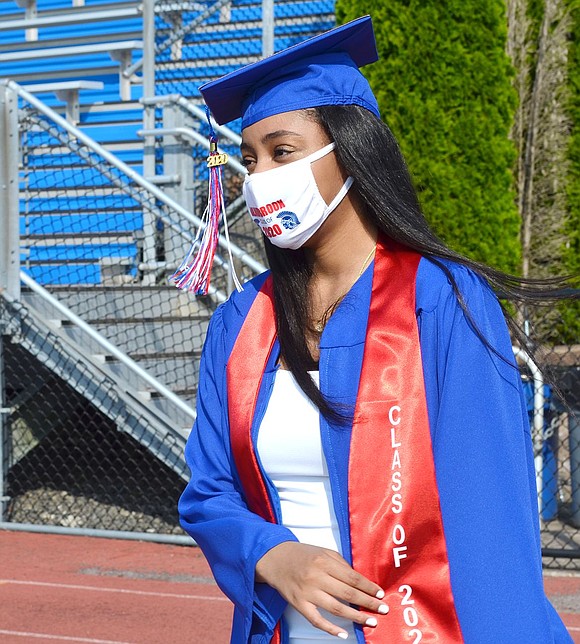 Masked by a custom Blind Brook Class of 2020 face covering, Gabriella Cuevas Lugo wistfully looks onward to the future as she marches onto the football field.