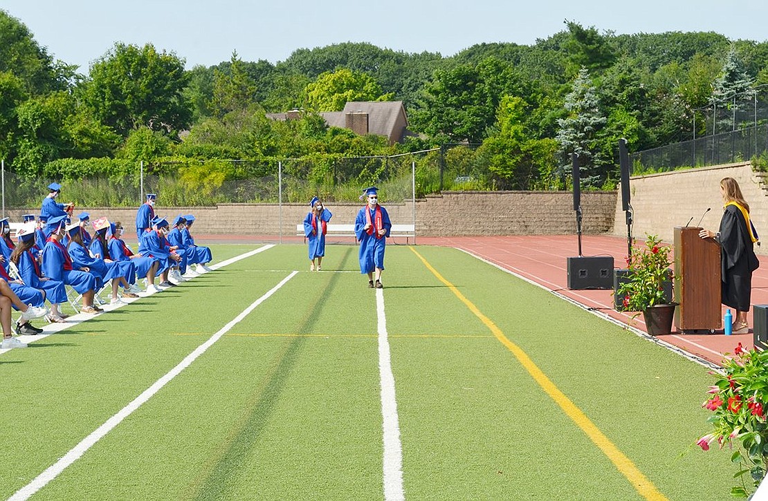 As the first name called during the commencement ceremony, Ryan Aiello marches in front of his peers to collect the first Class of 2020 diploma.