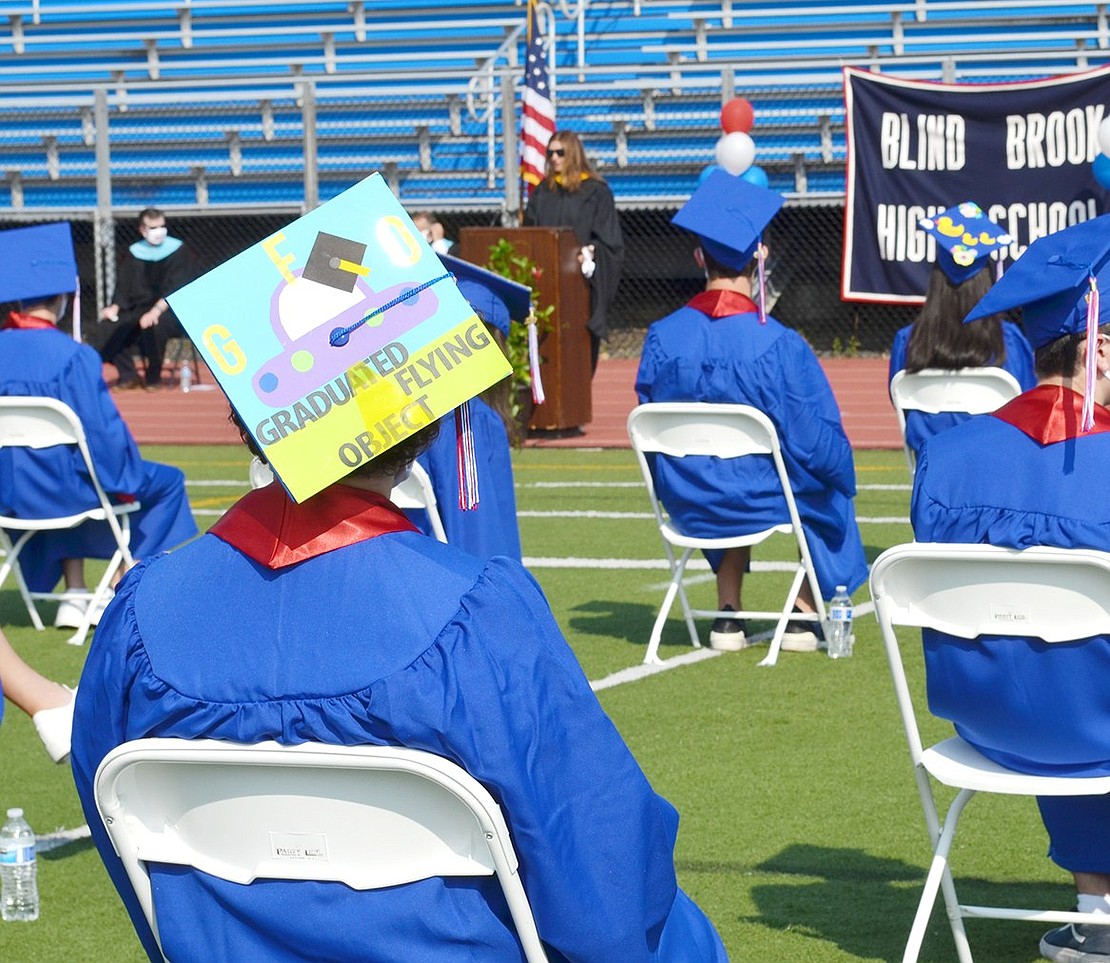 While listening to Senior Class Advisor Charlene Decker welcome the graduates, Peri Glick sits in her socially distanced chair donning her creative “Graduated Flying Object” cap.