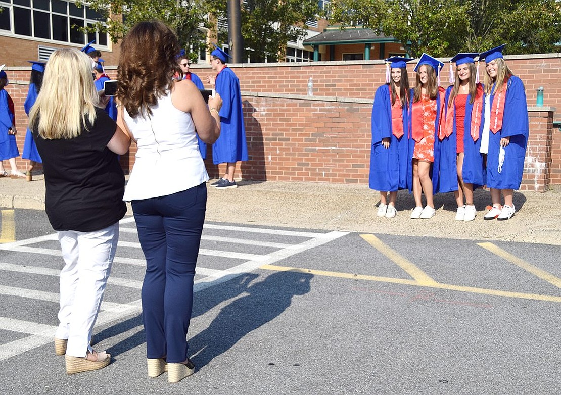 With proud parents getting ready with their cameras, Amanda Weinberg (left), Rachel Sosin, Julianne Vavolizza and Jami Weintraub line up to pose in matching caps, gowns and Class of 2020 sashes before the ceremony.