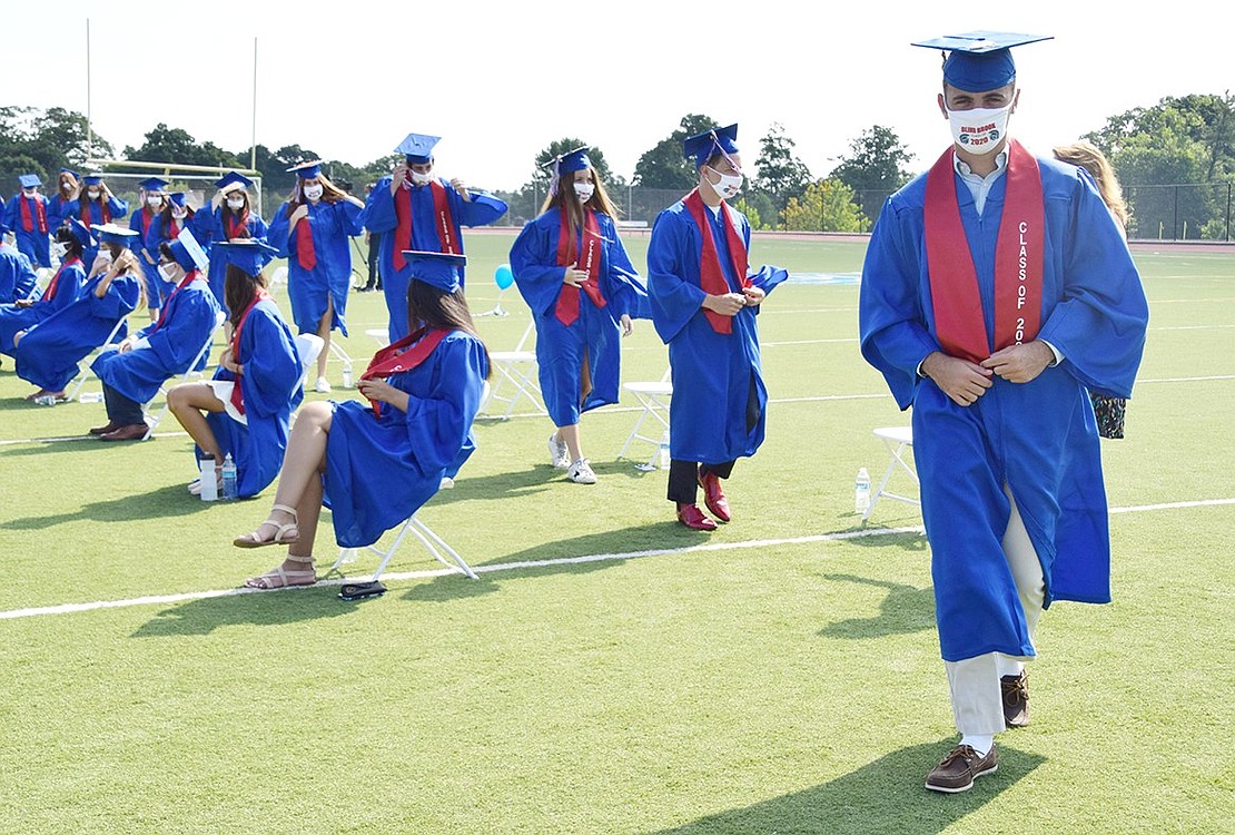 John Banahan straightens out his sash while lining up with his row of peers getting ready to officially graduate from Blind Brook High School.