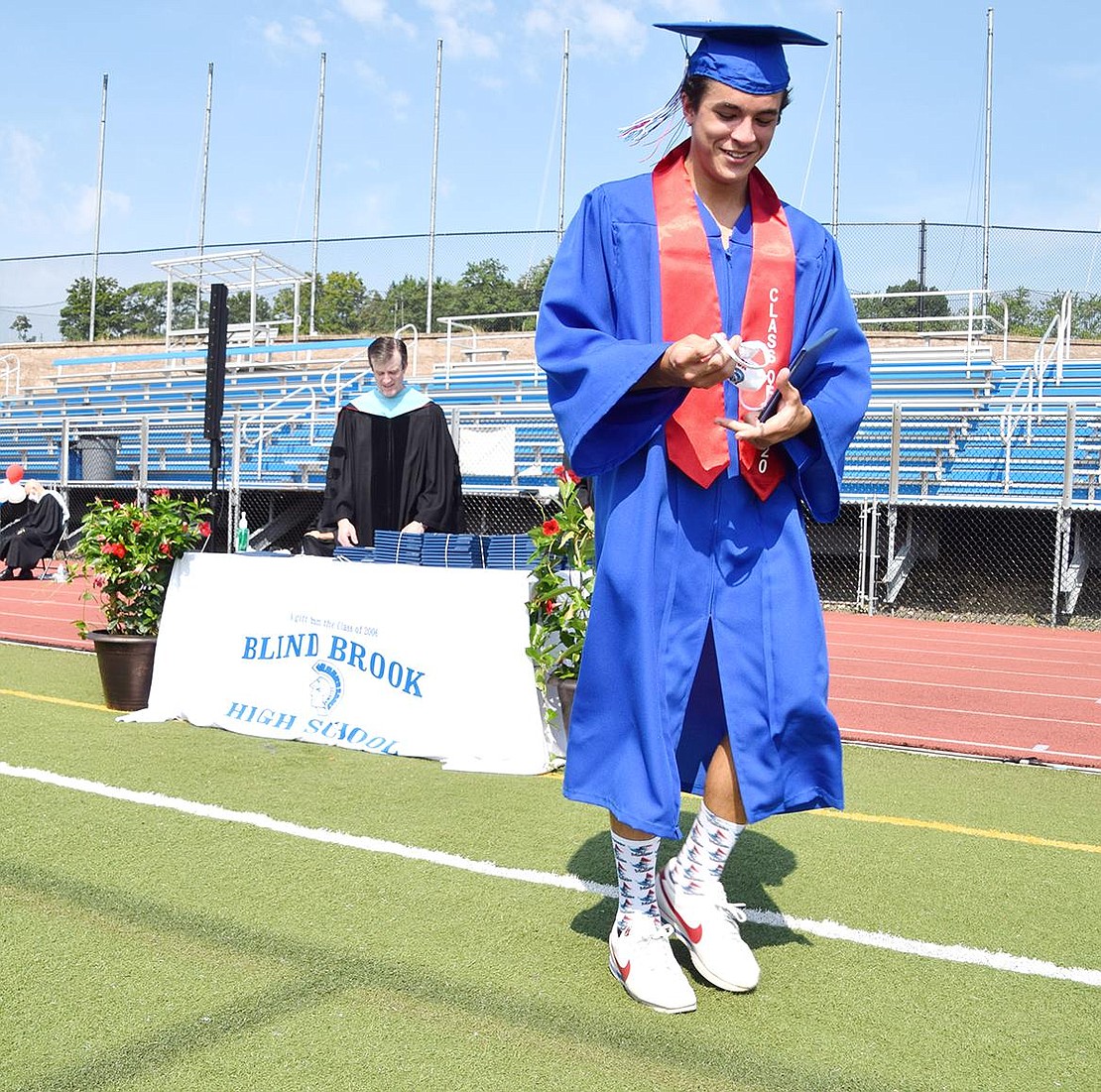 He finally did it. Michael Lieberman smirks to himself as he unfolds his mask and walks back to his seat with his degree.