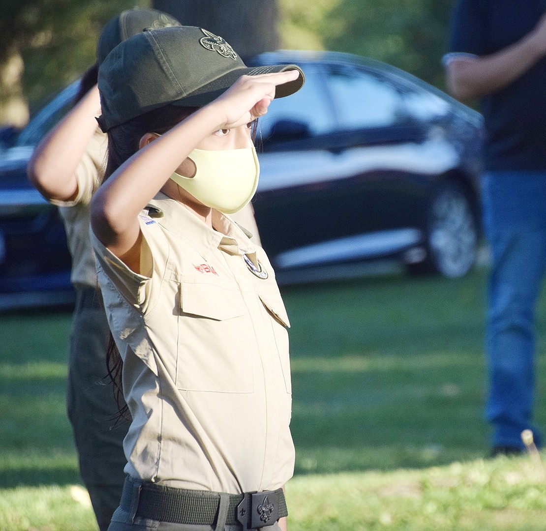 Boy Scout Troop 400 member Ariana Ayala, 11, holds up the Boy Scout salute during the 9/11 ceremony in Lyon Park.