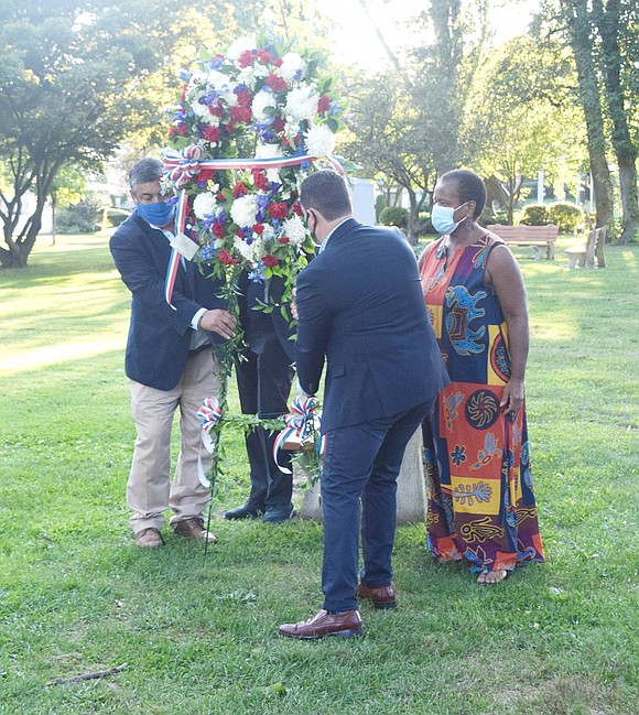 Port Chester Trustees Luis Marino (left), Alex Payan and Joan Grangenois-Thomas pick up a commemorative wreath to place at the 9/11 memorial in Lyon Park.