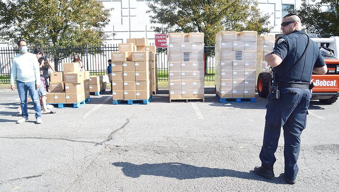 Several palettes of food line the parking lot adjacent to Westy Self Storage as volunteers prepare to help individuals and families load the boxes into their trucks.