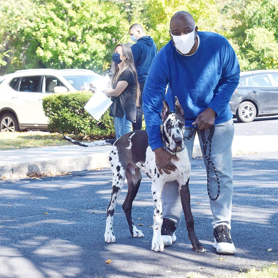 White Plains resident Russell Fulmore holds onto his dog Dexter, who eagerly wants to go play with the other, much smaller dogs waiting to receive their blessings.