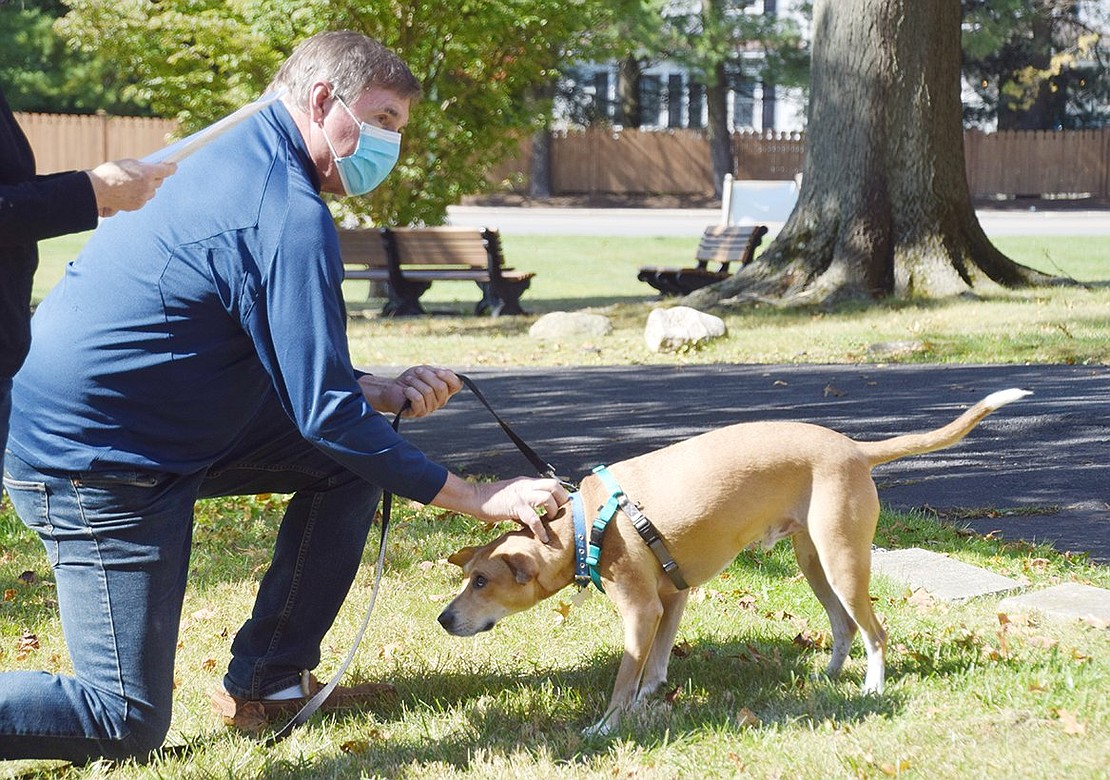 Stamford, Conn., resident Chip Gawle pets his dog Sammy to remind him he is a good boy before he receives a blessing.