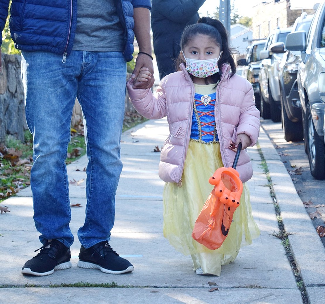 Dressed as the princess Snow White, Mia Zhuin, 2, holds onto to her trick-or-treat bag in anticipation of getting some sweets.