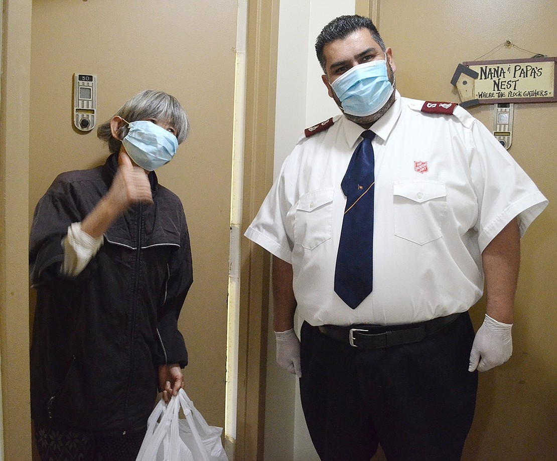 Terrace Avenue resident Moin Chen gives a thumbs up after accepting her turkey dinner from Major Samuel Alarcon from the White Plains Salvation Army where the turkeys were cooked and meals apportioned into containers. Food was donated this year by La Fontaine in Somers and the Tarrytown Marriott, with executive chef Michael Devlin going in on his own to cook even though the hotel’s kitchen is not really open. “Each of the 34 years there is something different, and this year it is the pandemic,” said Ray Francis of Somers, who has been coordinating the operation for many years.