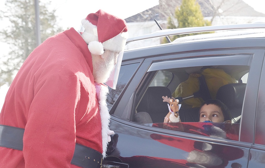 Port Chester resident Lucas Molleturo, 8, shows Santa Claus his new reindeer toy during a free Holiday Drive-Thru event sponsored by SPRYE in Crawford Park on Saturday, Dec. 19. The Port Chester based organization offers helpful services for people over 60 years old in Rye and its environs.