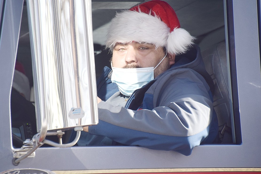 Dressed in traditional Christmas attire, Putnam Engine & Hose Company firefighter Steve Contreras looks on as the departments makes their way through Port Chester.