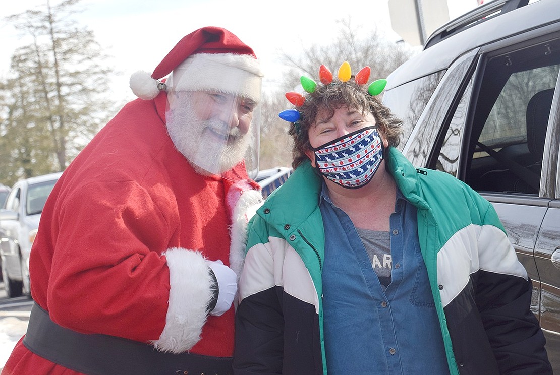 SPRYE Executive Director Marie Johnson poses with Santa Claus, who secretly goes by Charlie Sacco, during the organization’s Holiday Drive-Thru.