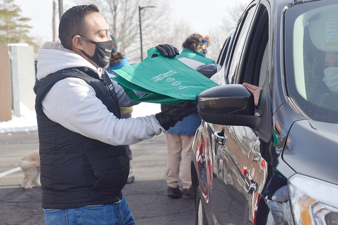 The First Bank of Greenwich Relationship Manager Christian Sanchez gives out a free tote bag.