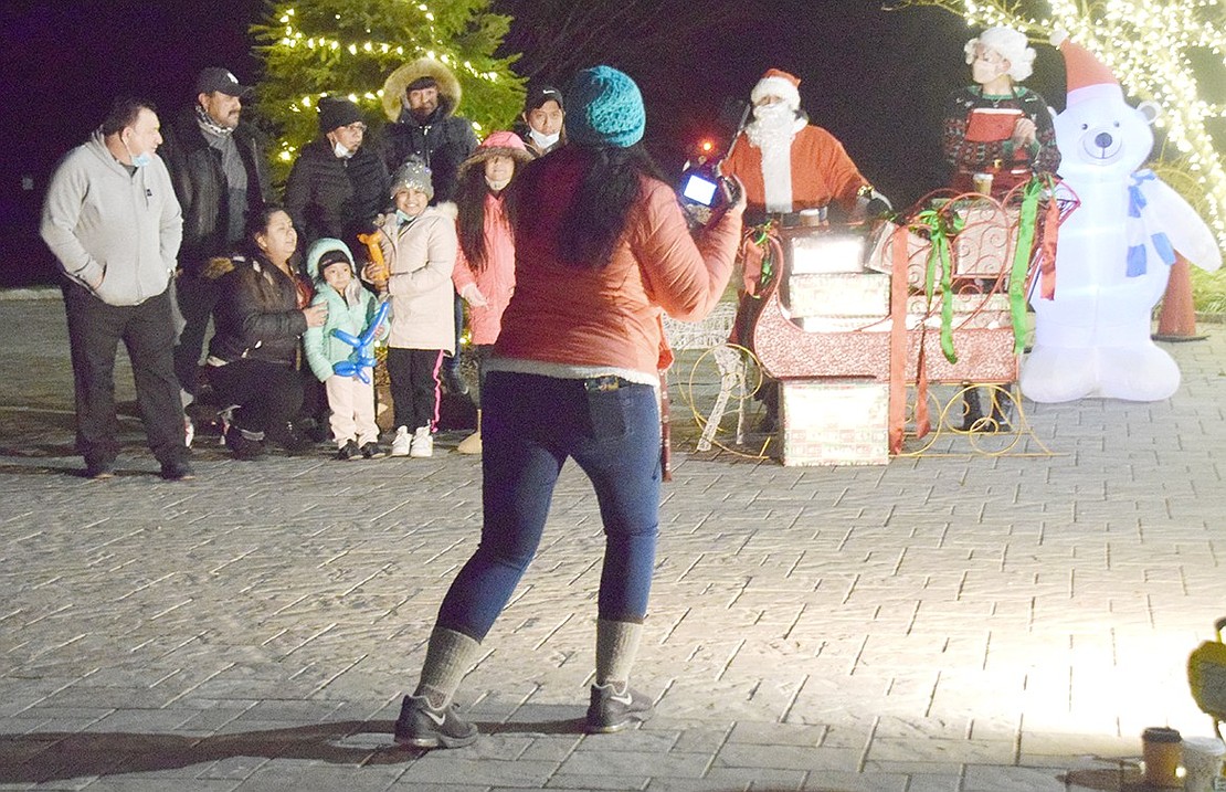 Mahopac resident Naomi Bowen, the official Holiday Drive Through photographer, directs families into the proper position to take the perfect Christmas photo. Groups were instructed to sit in their cars and wait their turn to approach Santa alone to limit gathering.