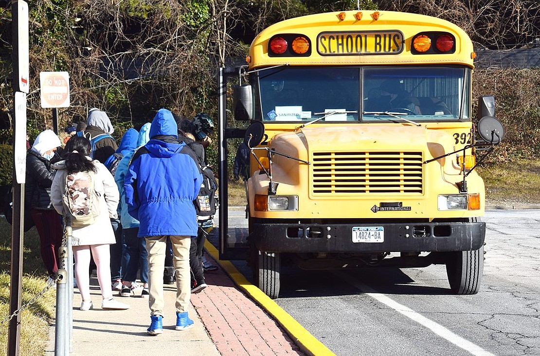 A group of Port Chester Middle School students line up to file into a school bus to take them home for the day.