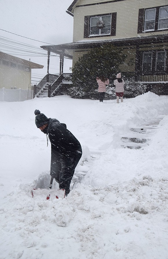 Anthony Bollard shovels the steps at 438 Westchester Ave. where he lives during Monday’s storm.