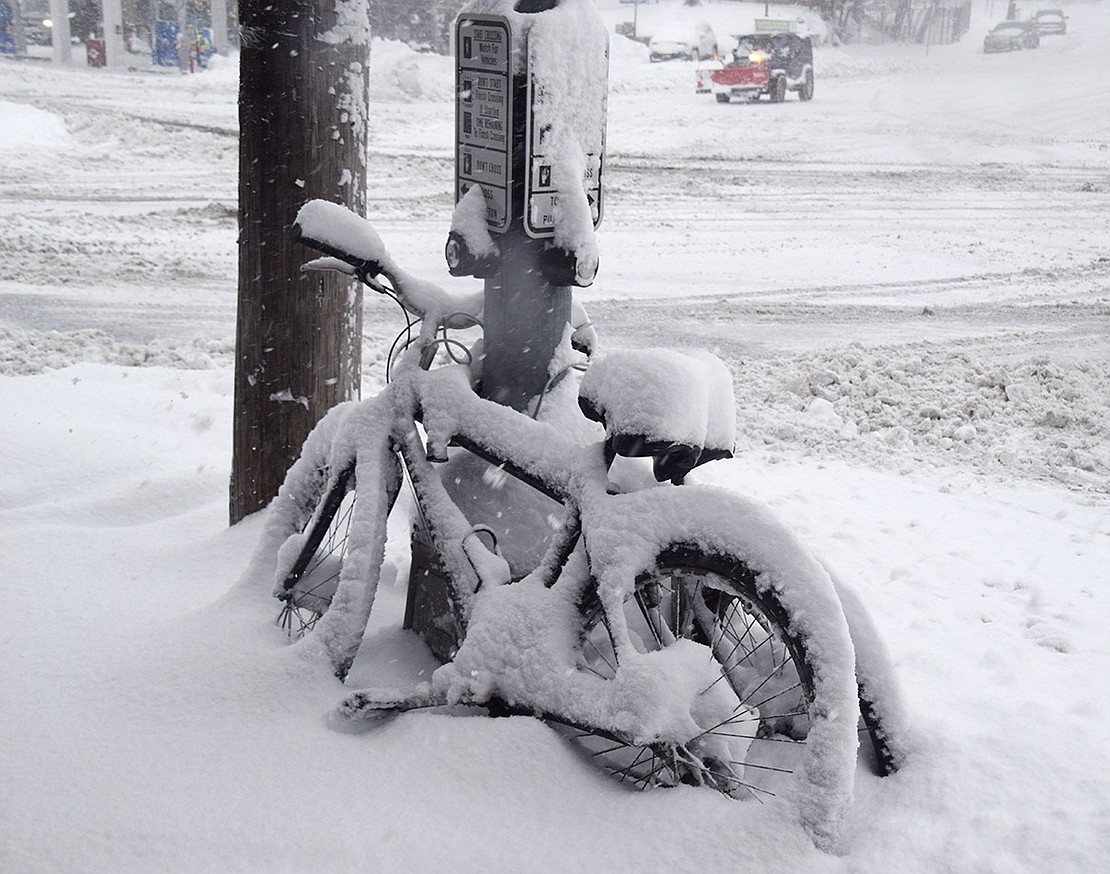 Snow-covered bicycles locked up around a pedestrian signalization pole at the corner of Willett Avenue and King Street won’t be going anywhere anytime soon.