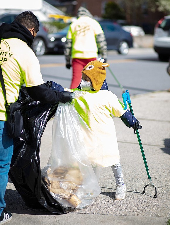 Selina Alvarado, 5, helps her family pick up trash outside the Port Chester-Rye Brook Public Library. Her family spent two hours cleaning the community, making a route from the Metro-North train station up along Westchester Avenue and back.