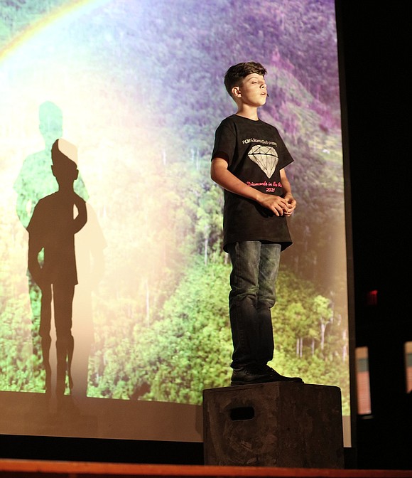 A first-time middle school performer, sixth-grader Nicholas Villanova sings “Somewhere Over the Rainbow” from “The Wizard of Oz” from atop a wooden prop box.