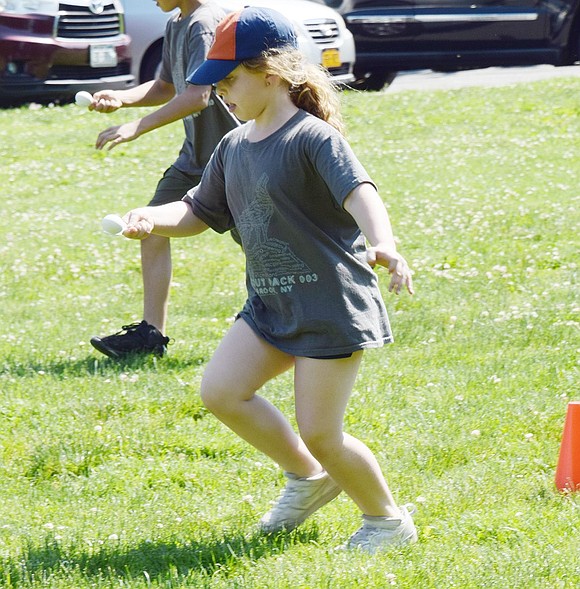 Ridge Street School first-grader Abigail Gitkind pulls all kinds of balancing maneuvers to get her egg to the finish line unscathed during an egg race.