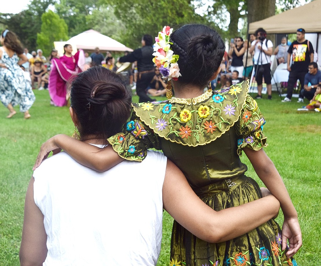 After finishing her performance, Port Chester 7-year-old Nathaly Cabrera and her mother Flor watch other cultural dances together. While the Caring & Loving Foundation traditionally raises money for kids with disabilities, contributions made at the International Festival will be used to buy laptops for local students. Trustee Alex Payan, who helped organize the event on the municipal side, will be facilitating the donation.