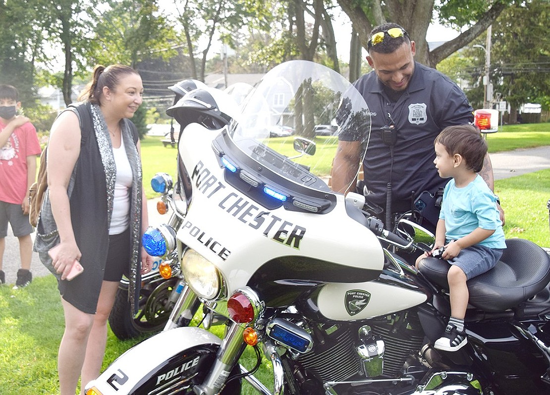 Proudly looking at his mother Jessica Taleon, 3-year-old Prospect Street resident Leonel Taleon can’t even reach the handle bars on the police motorcycle Officer David Arroyo lifted him onto.