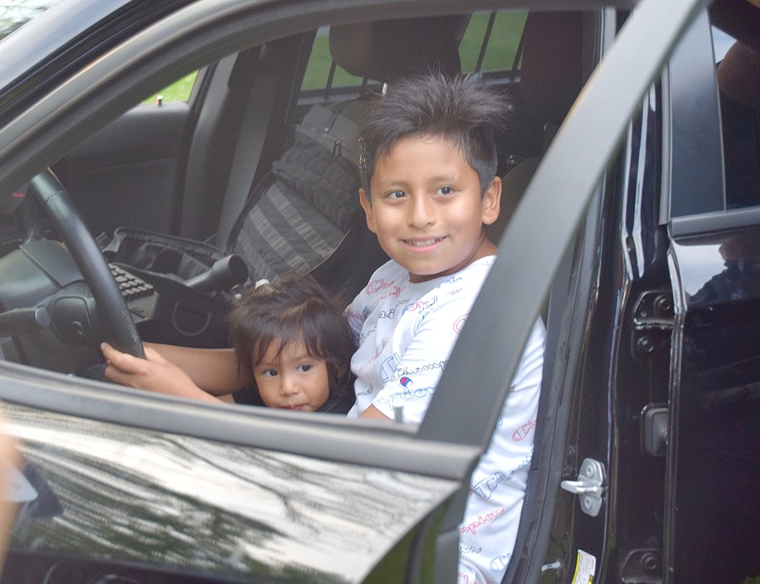 Westchester Avenue children or future law enforcement partners? Maximo Salazar, 1, sits on his 11-year-old cousin Gianmarco Soto’s lap as they pose for a photo while pretending to drive a police cruiser.