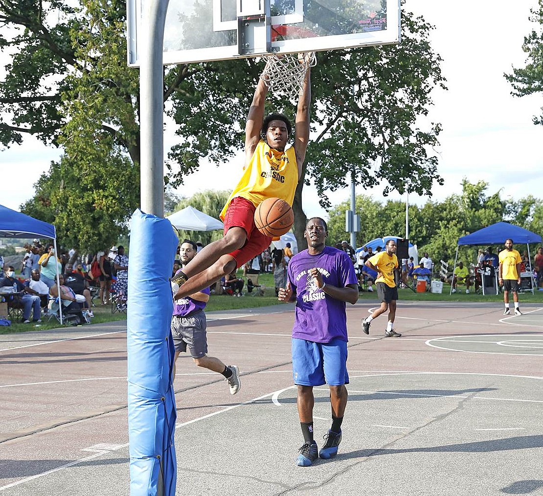 Weber Drive resident Shamel Jones, 19, hangs onto the rim of the hoop while King Street resident AJ Foust, 34, runs behind for the rebound during the traditional Unity Day basketball tournament on Saturday, Aug. 14. Each year, current and former Port Chester Housing Authority residents gather in Columbus Park for the reunion. Last year would have been the 30th anniversary of the event, but smaller gatherings were held in lieu of the large celebration due to COVID-19.