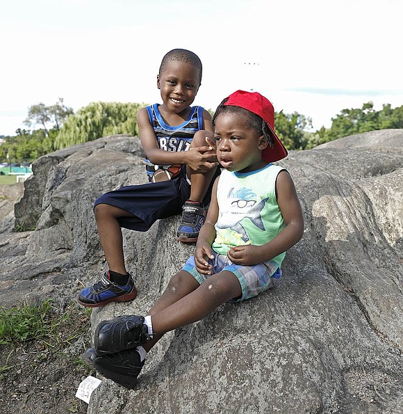 Major Jones (left), a 4-year-old, and his younger brother Legend Smith, 2, hang out on a Columbus Park rock at Unity Day. Both boys live in Port Chester and attend Tater Tots Day Care.