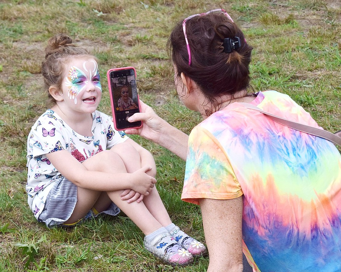 A picture’s worth a thousand words. Hawley Avenue resident Cora Mercaldi, 4, offers up a big smile for the camera while her mother Amanda captures a precious Port Chester Day moment at Lyon Park on Saturday, Aug. 28 by snapping a shot of her vivid butterfly face painting.
