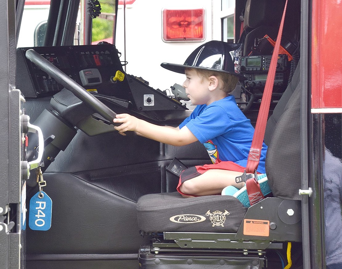 The Port Chester Fire Department may have found their newest firefighter as Rye Brook resident Spencer Sheer gets a kick out of exploring their engines on display for children.