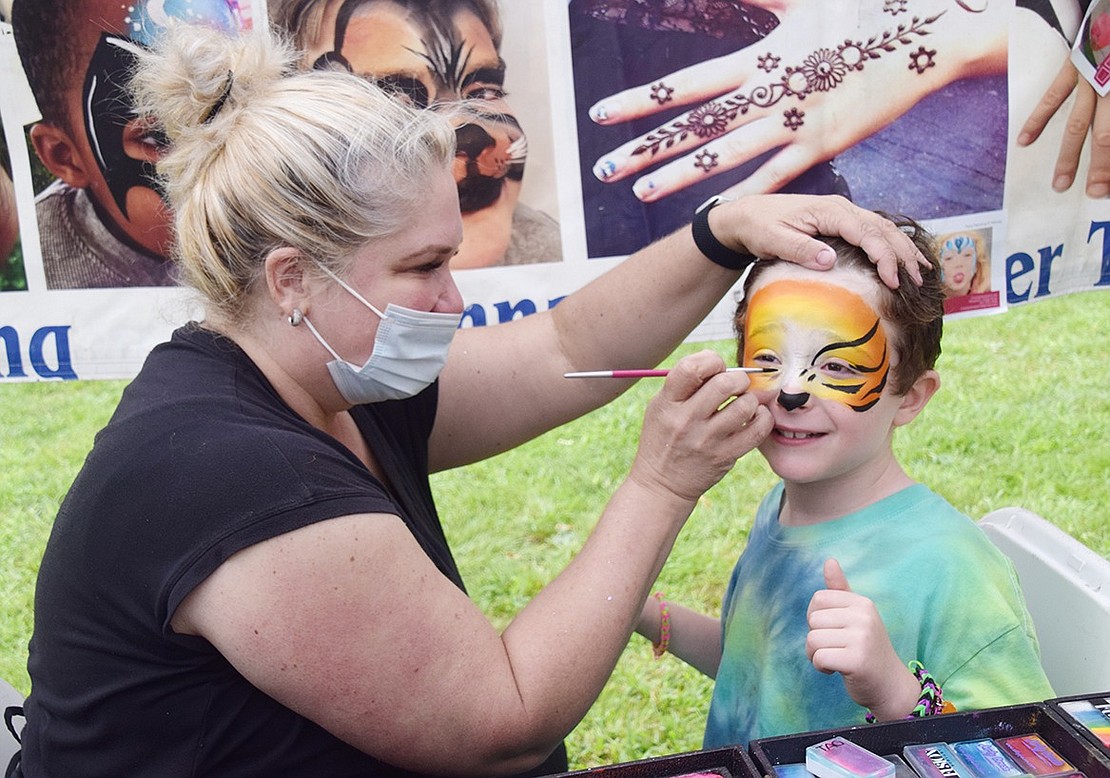 Rye Brook 7-year-old Eli Taub expresses pure enthusiasm as an artist with Cheeky Designs turns his face into a tiger.
