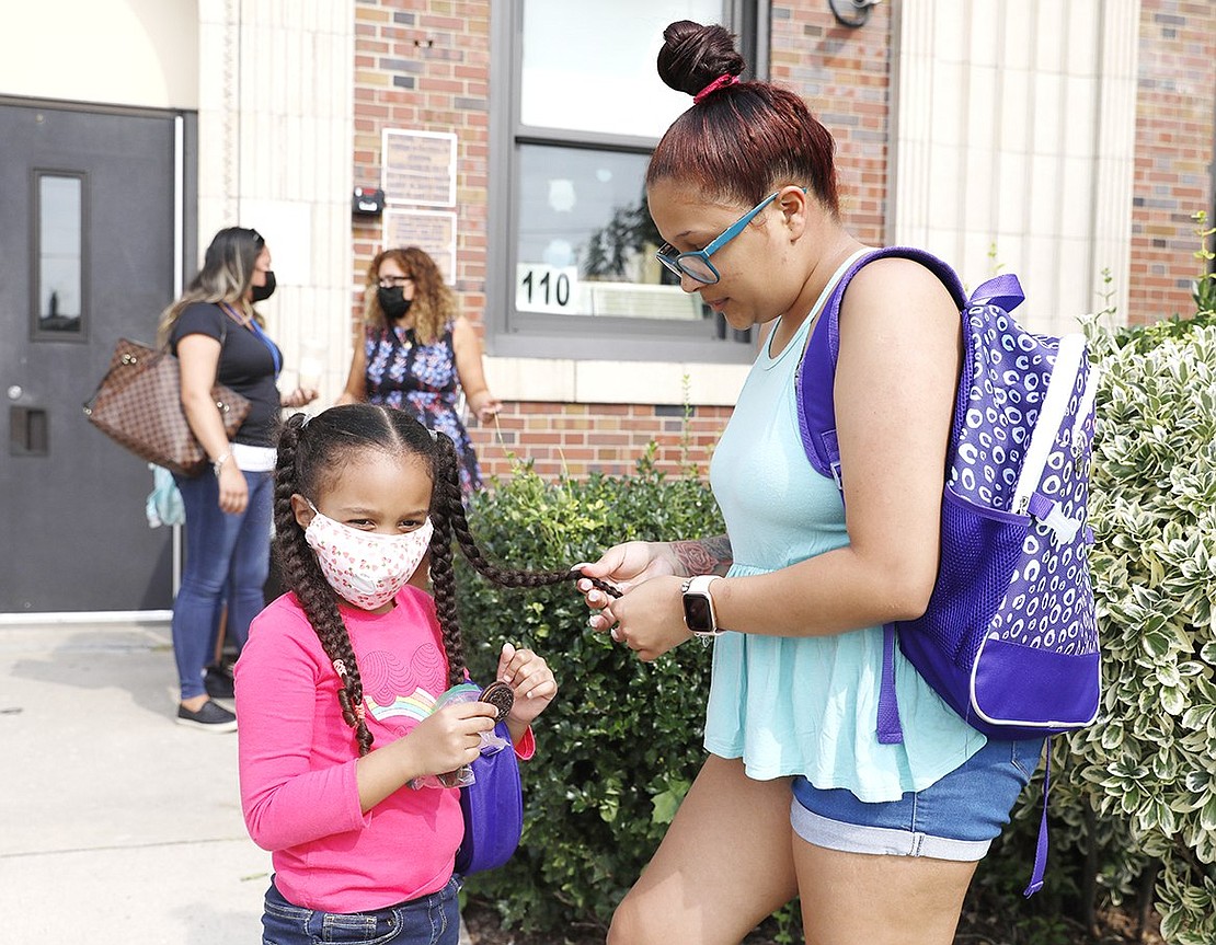 Sairy Diaz (right) fixes her daughter Kimberly Diaz’s braids as the Park Avenue School kindergartener eats Halloween-themed Oreos after class on Tuesday, Sept. 14.