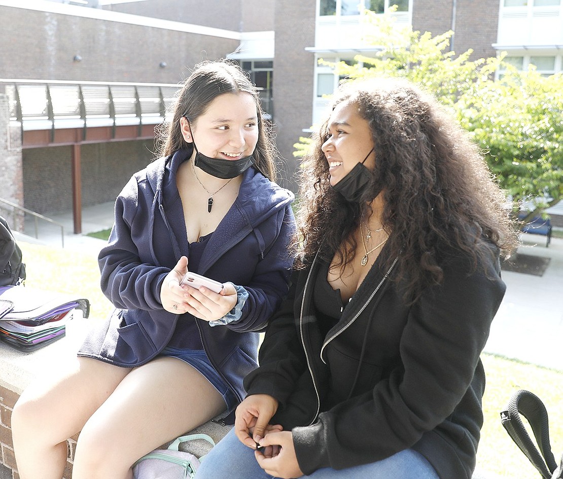 Port Chester Middle School eighth-graders Katherine Angulo (left) and Jennifer Perez chat and laugh together as they wait for their ride after class on Monday, Sept. 13.