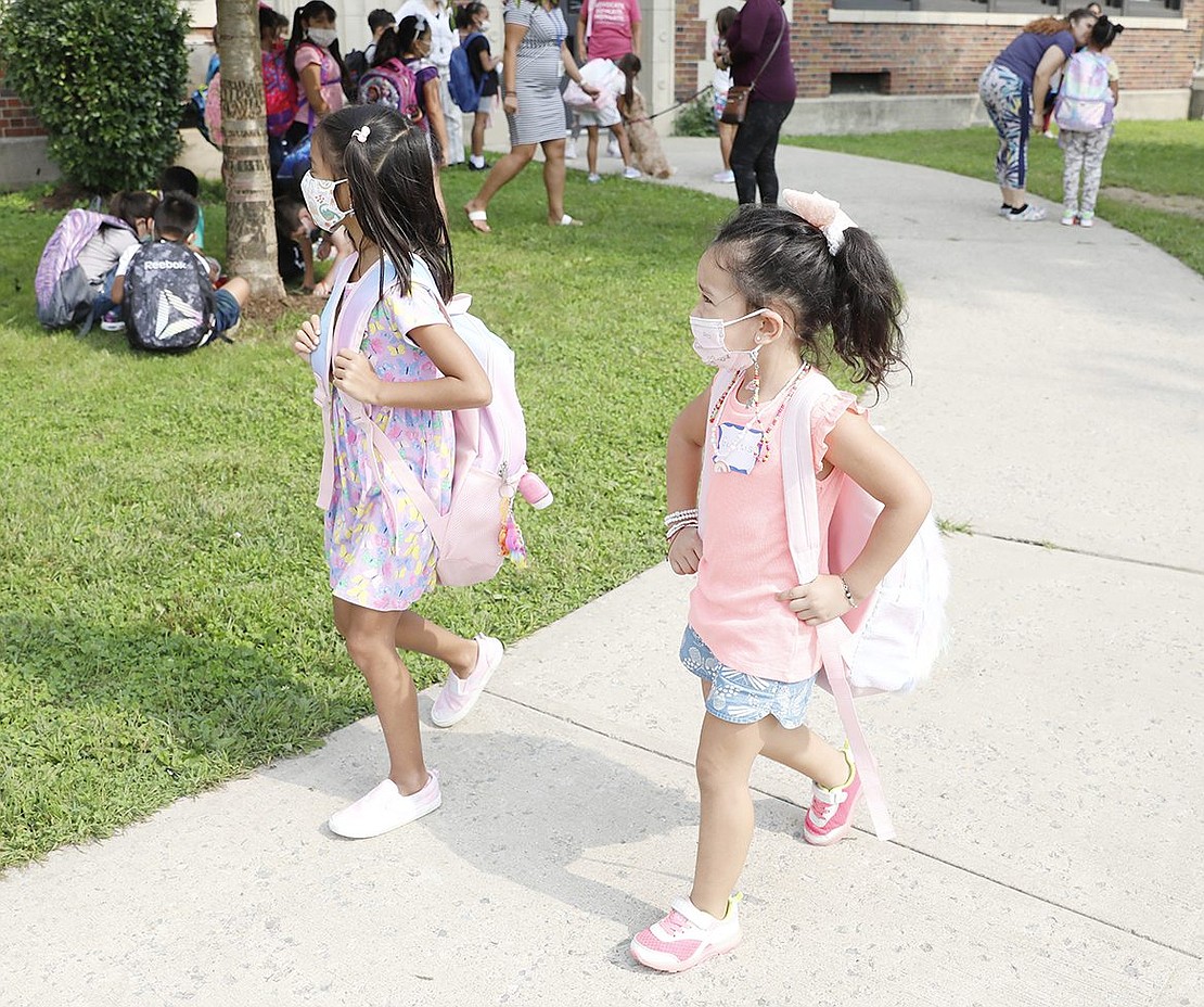 Preschooler Genesis Barrera (right) and her friend, first-grader Victoria Martinez, walk together after school at Park Avenue School on Tuesday, Sept. 14.