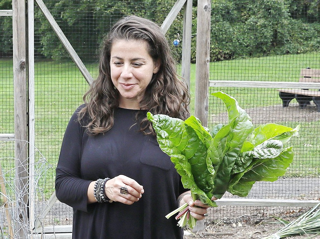 Family and Consumer Science teacher Allison Silverman, who founded and oversees the Giving Garden, looks on with joy as her students pick Swiss chard. “I love Ms. Silverman,” eighth-grader Scarlett Pimenteo said of her Garden Club teacher. “She just radiates good energy, so it’s just fun to do stuff with her.”