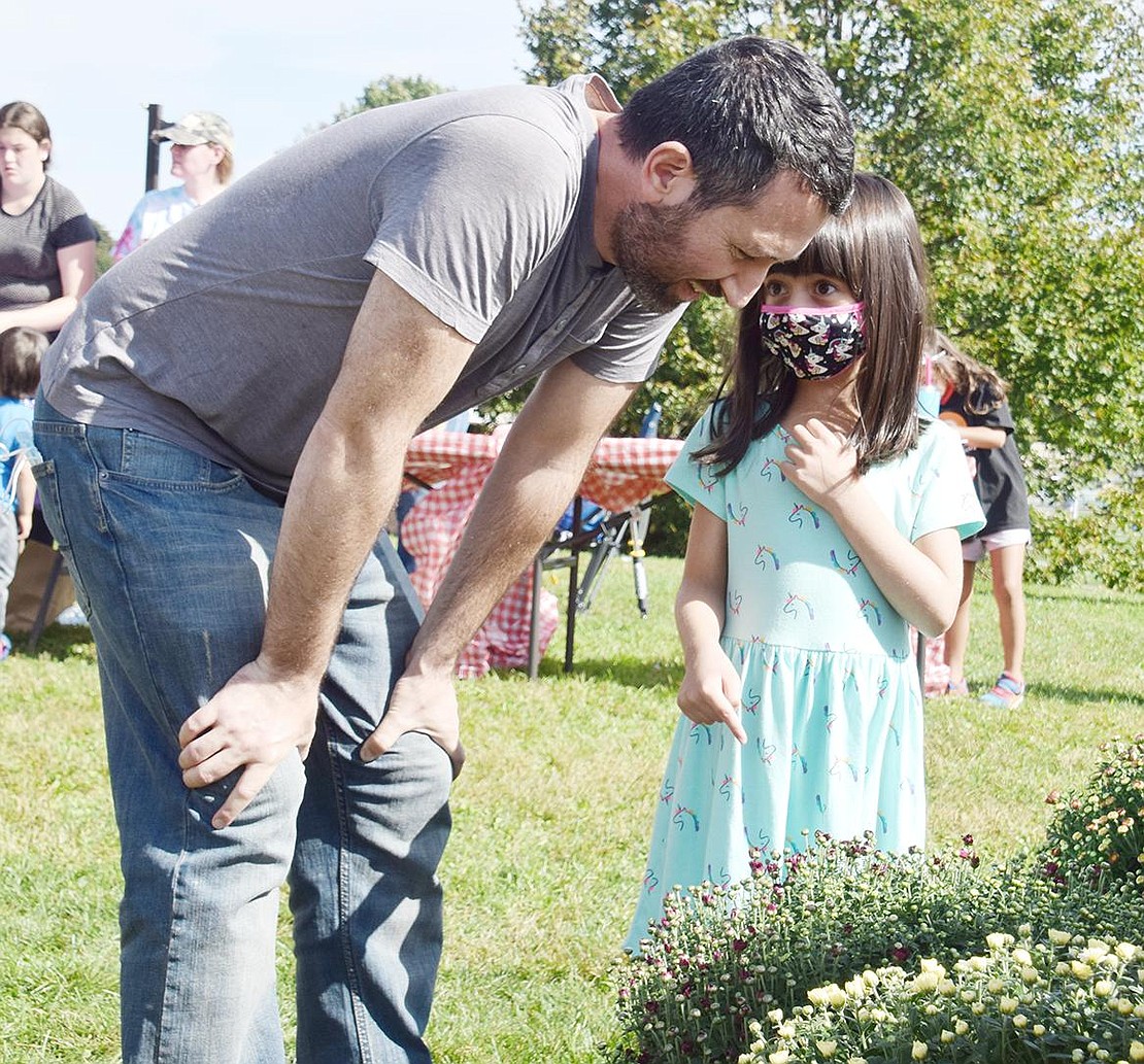 Plants are big responsibilities; the whole family should be involved with getting one! Ridge Street School kindergartner Molly Greenberg points out her favorite plant to her father Eric, which he soon after carried away to buy.