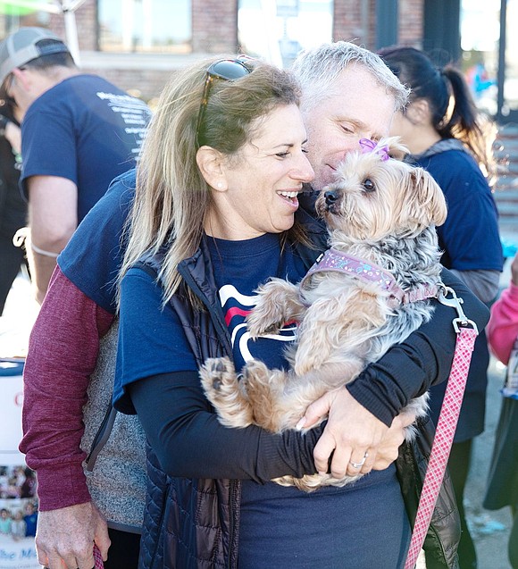 Holly Hyman, of Stamford, Conn., dances to the post-race music with Bella the dog in her arms, as Howie Kurzurk, of Long Island City, adores the fuzzy friend.