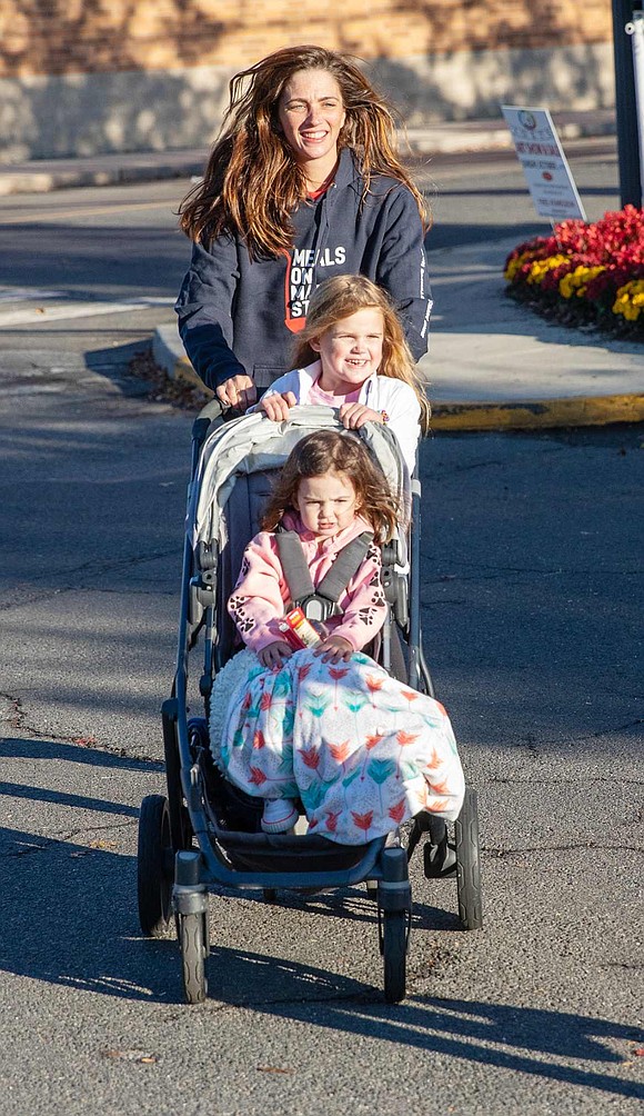 Harrison resident Meghan Charles, who co-chaired the event, pushes a stroller with Nell and Mae McGough in it.