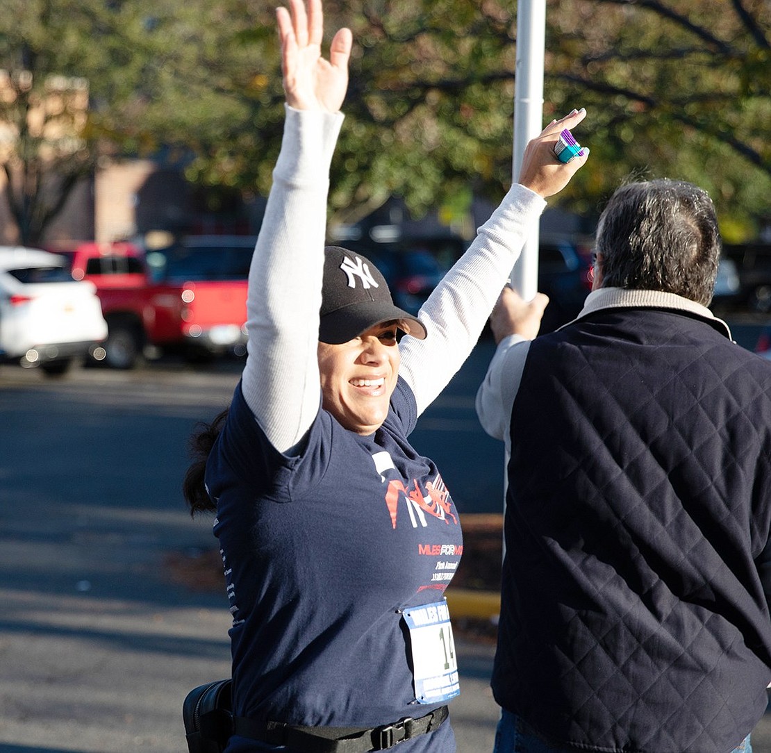 Angela Perdomo, of Port Chester, puts her arms in the air in celebration the moment she finishes the course.