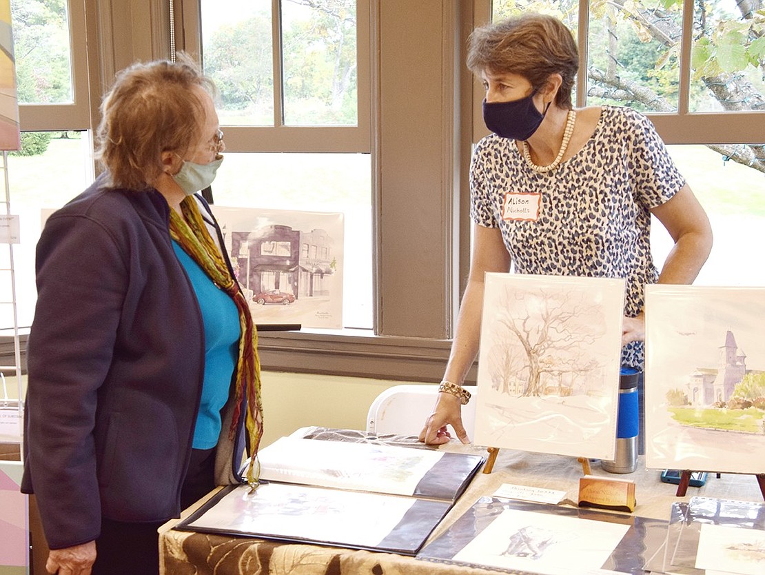 Port Chester resident Alison Nicholls (right) chats with Margaret Nierodzinska, a longtime Port Chester resident who now lives in New Rochelle, about her charitable Painting 10573 local landscapes project on display.