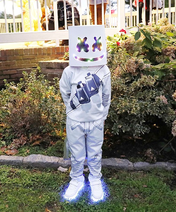 Corpus Christi-Holy Rosary School first grader Christopher Fonseca, dressed as the DJ Marshmallow, shows off his flashy costume. Children from across the Village gathered at Lyon Park for a costume contest, treats and dancing.