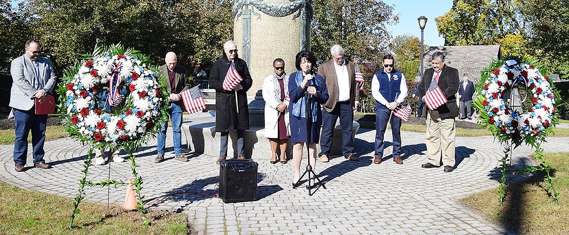 Rye Town Clerk Hope Vespia, surrounded by Port Chester and Rye Town officials, says a prayer as the ceremony begins.